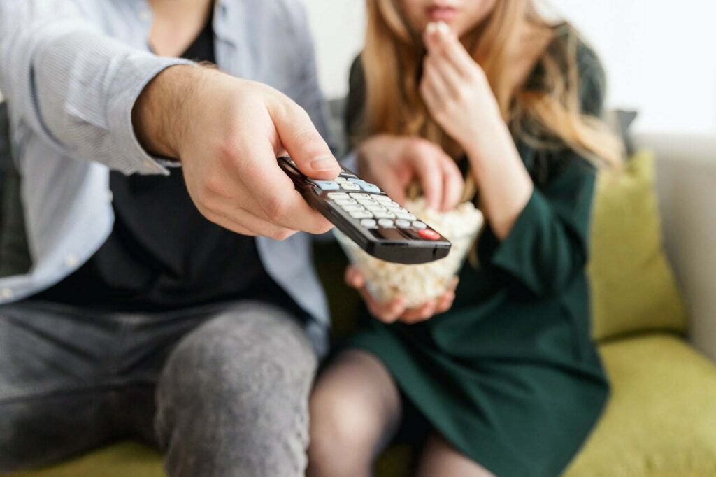 couple holding tv remote