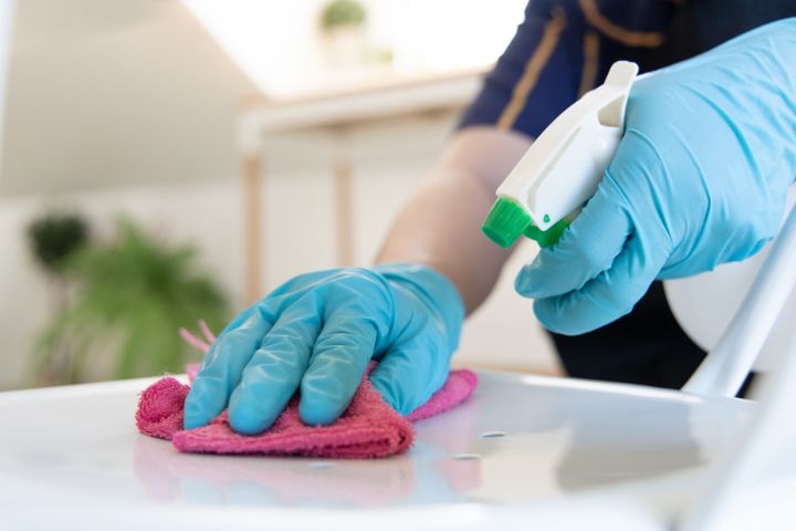 Person cleaning something with a spray bottle and cloth