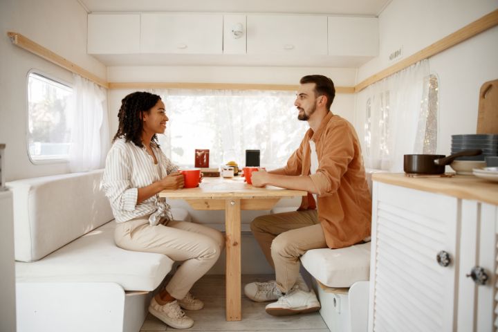 Two people sitting at a dining room table in a caravan