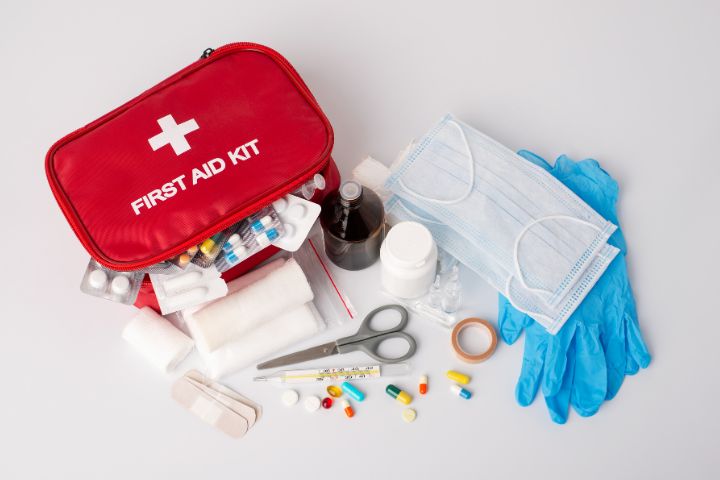 Red first aid kid with a mask. gloves, tablets, plasters and bandages