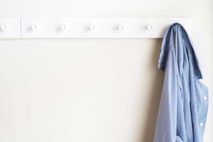 white coat hooks with a jacket hanging on them