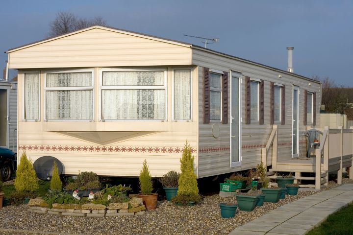 Static caravan surrounded by plants