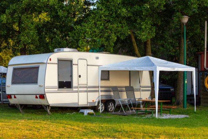 Touring caravan with a gazebo and tables and chairs attached